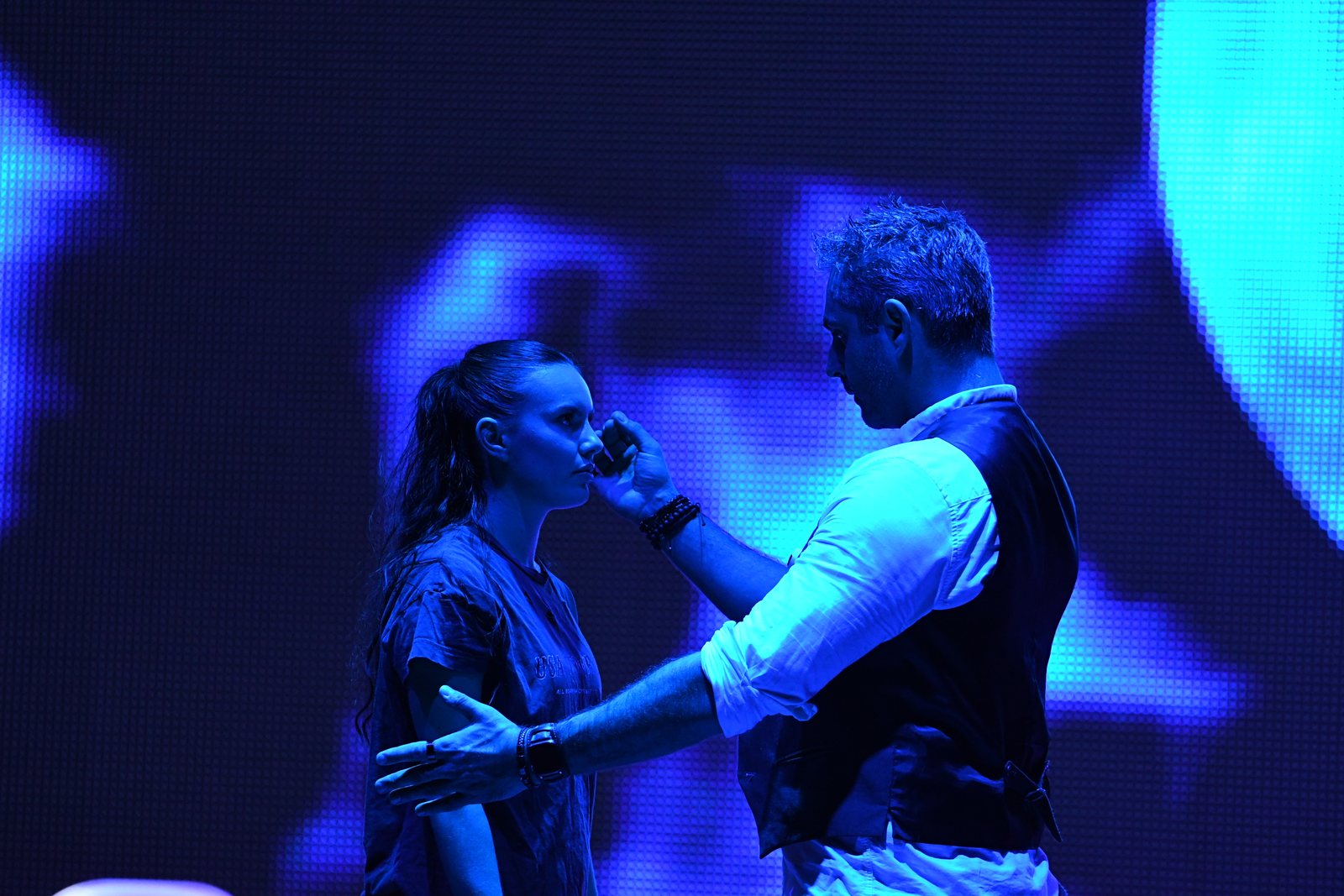 Phoenix holding the microphone for a volunteer on stage