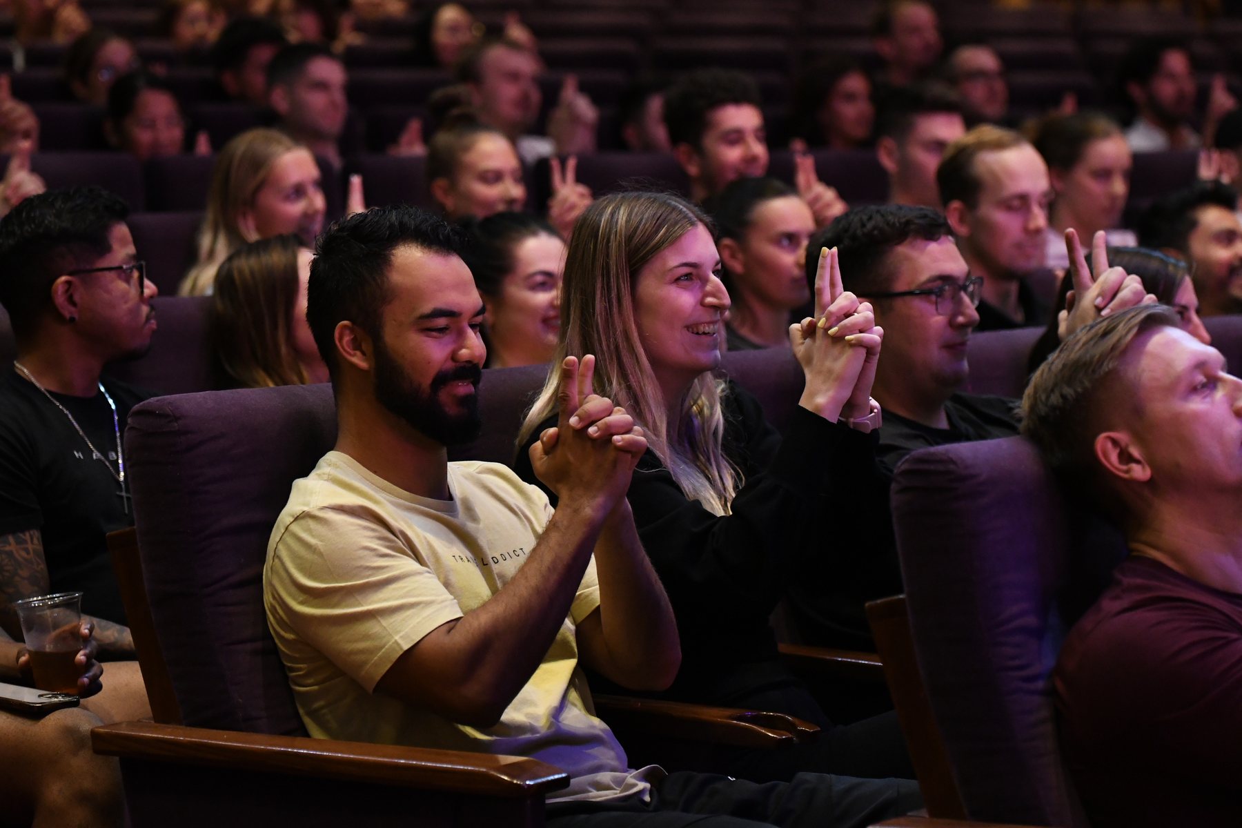 Audience members laughing and pointing during the comedy hypnosis show