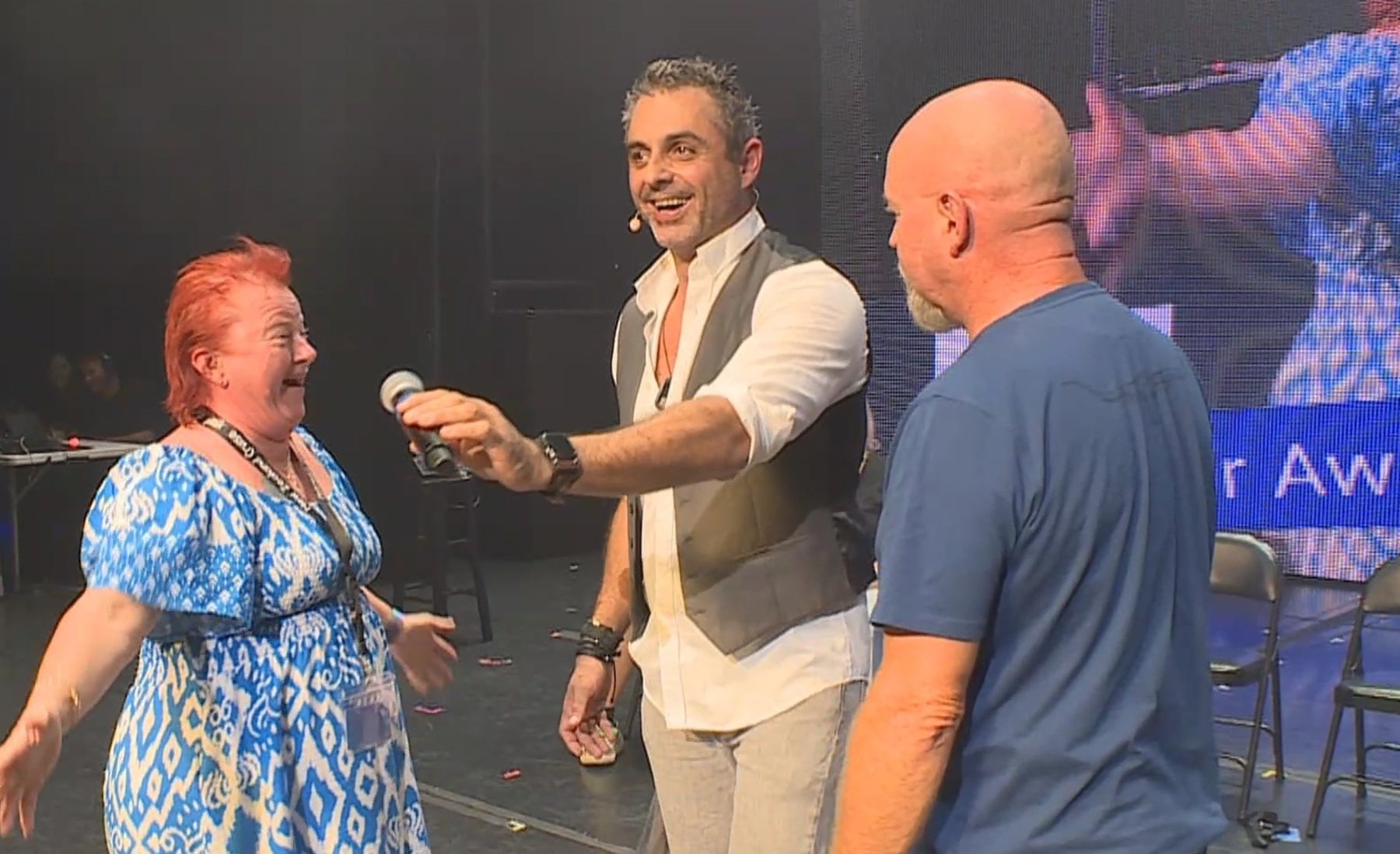 A row of volunteers on stage reacting all at once during the comedy hypnosis show