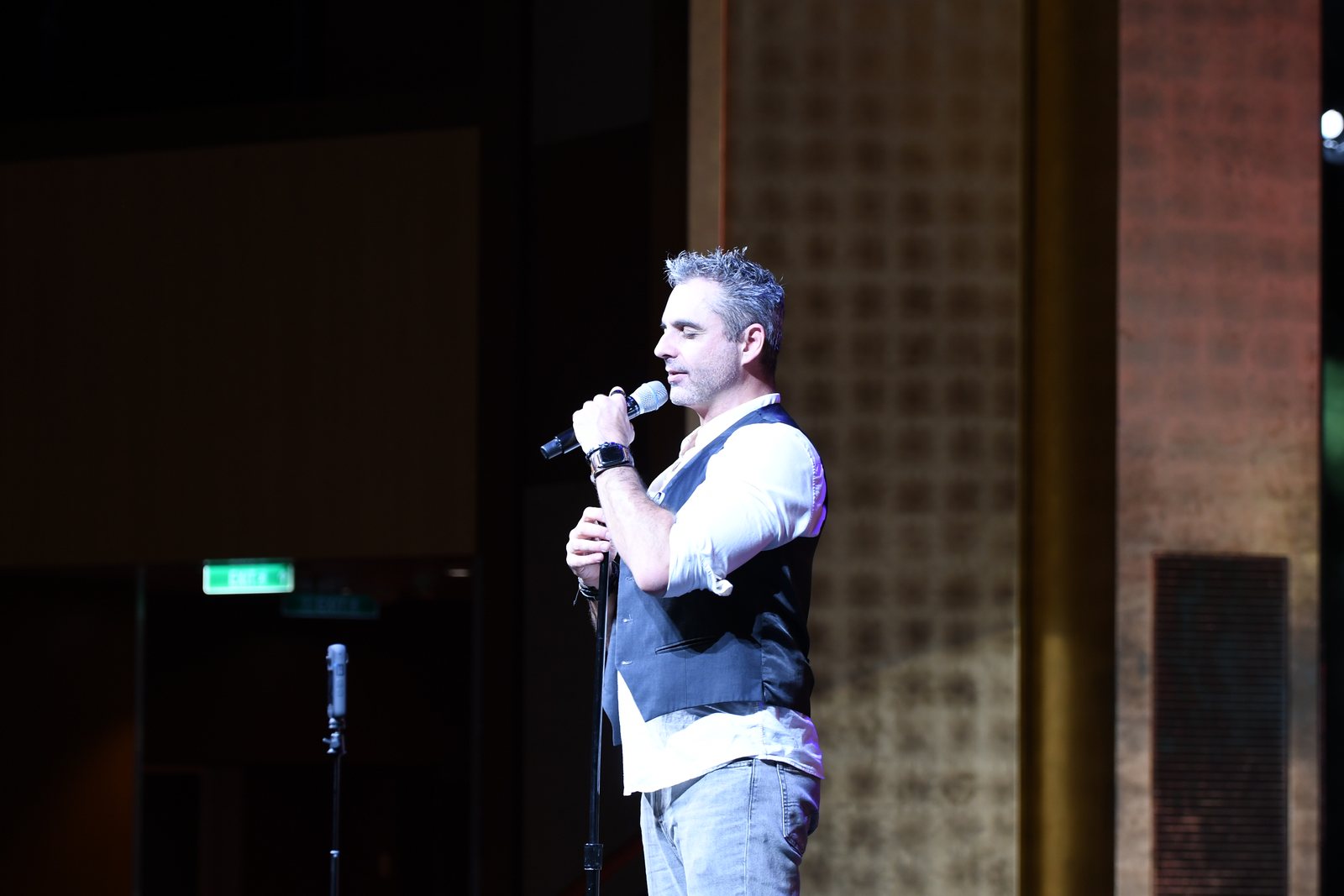 Phoenix on stage with a microphone during the comedy hypnosis show